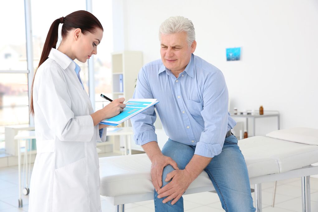 El médico prescribe un tratamiento para un paciente con artrosis de la articulación de la rodilla.