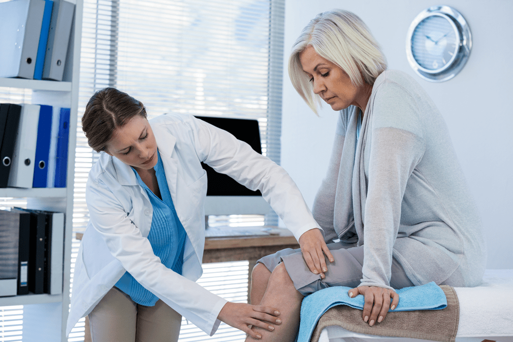 Un paciente con artrosis que necesita terapia, examinado por un médico.